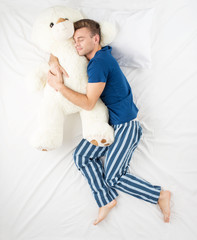 Man sleeping with large teddy bear