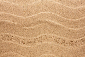 Fototapeta na wymiar Goa inscription on the wavy sand