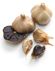 black garlic bulbs and cloves on white background © uckyo