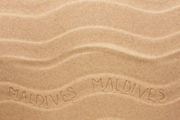 Maldives inscription on the wavy sand