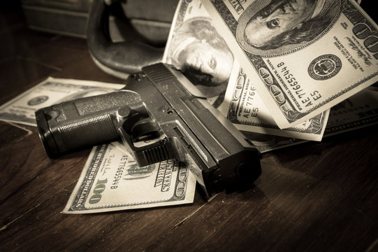 Sepia filtered of gun and dollar bills