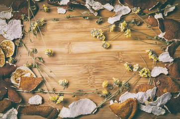 frame of dry citrus peel and withered flowers in vintage look
