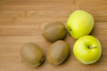 yellow apples and kiwis on wooden table