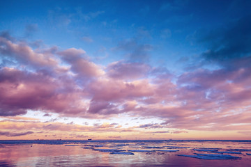 Fototapeta na wymiar Winter coastal landscape with floating ice on sea water