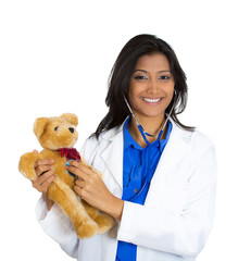 Happy female doctor with stethoscope holding teddy bear 