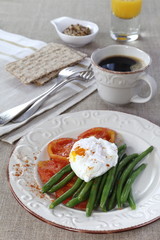 Healthy  breakfast: vegetables, poached egg, cup of coffee and j