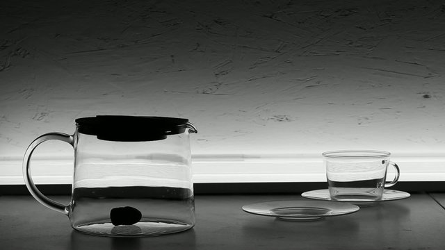 Pouring chinese green tea  into glass teapot
