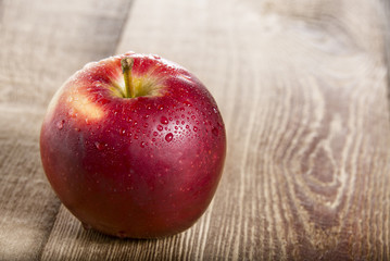 Ripe red apple on wooden table