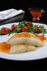 Flounder fillets in sauce with arugula and cherry tomatoes