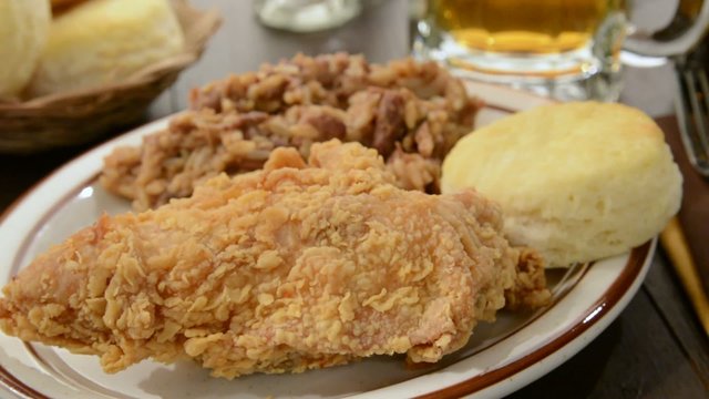 A chicken dinner being served with a mug of beer
