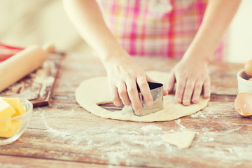 close up of hands making cookies from fresh dough