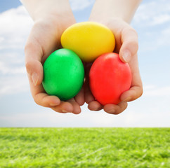 close up of kid hands holding colored eggs