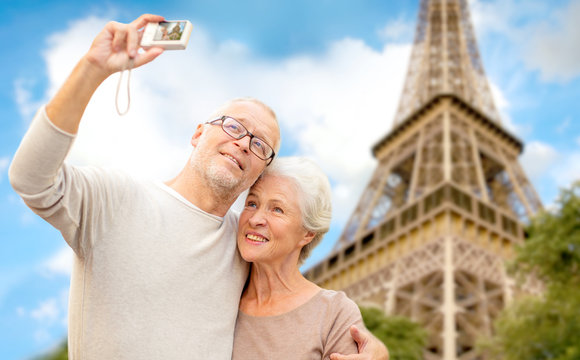 senior couple with camera over eiffel tower