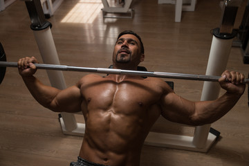 Bodybuilder Doing Exercise For Chest With Barbell