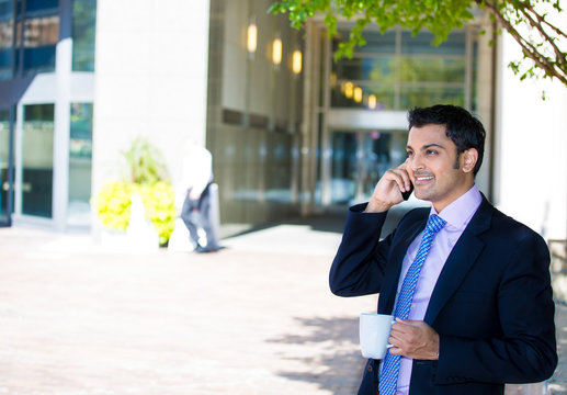 happy, smiling business man talking on phone  drinking coffee