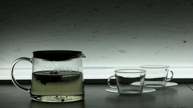Pouring chinese  green tea  into glass teacup
