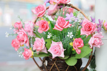 Beautiful flowers in basket hanging aside street.