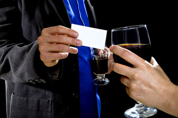 businessman handing over businesscard to a female at a bar