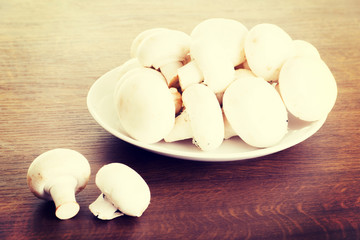Fresh raw mashroom lying on a plate.