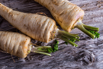 Fresh parsnip on old wooden table. 