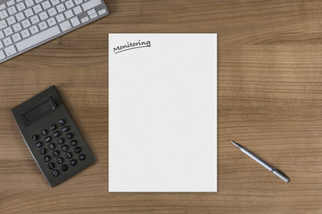 Blank sheet Monitoring on a wooden table with calculator