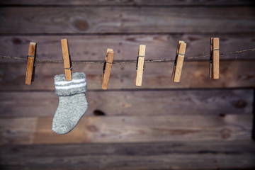 gray sock with a clothespin on a wooden background