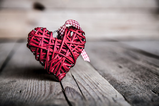 Red heart on a wooden background.