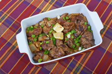 Fried chicken liver in a ceramic plate isolated on a checkered t