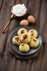 Cottage cheese pancakes and ingredients over wooden background