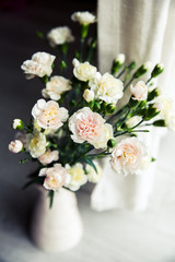 Obraz na płótnie Canvas delicate bouquet of carnations in a vase vintage. romance