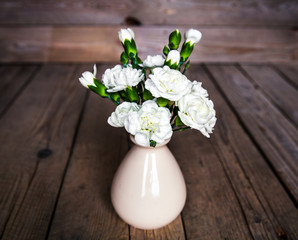 delicate bouquet of carnations in vintage vase with heart