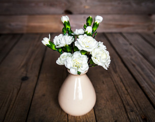 delicate bouquet of carnations in vintage vase with heart