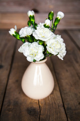delicate bouquet of carnations in vintage vase with heart