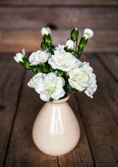 delicate bouquet of carnations in vintage vase with heart