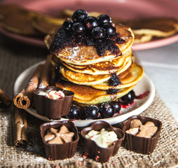 Picture of few pancakes with blackberries and sugar