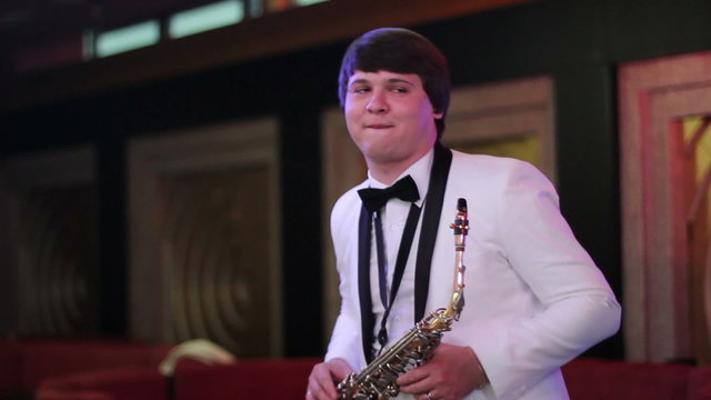 men in a white jacket  playing the saxophone