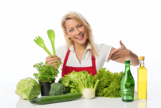Blonde Frau präsentiert Salat und Kräuter