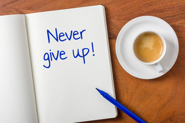 Notebook on a desk - Never give up