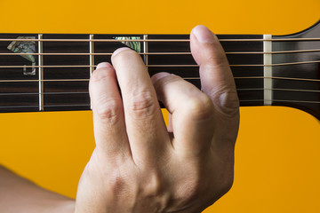 Hand performing F chord on guitar