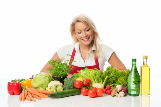 Blonde Frau schaut auf viele verschiedene Gemüsesorten