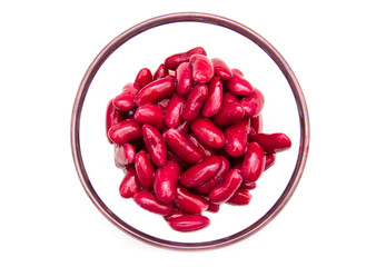 Red beans on the bowl on a white background seen from above