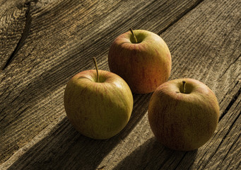 Drei Äpfel auf altem Holz