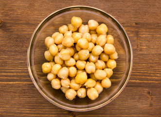 Chickpeas on glass bowl on wooden table