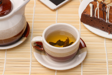 cup of organic chinese tea  with brownie cake