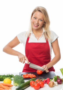Blonde Hausfrau schneidet Tomaten für einen Salat