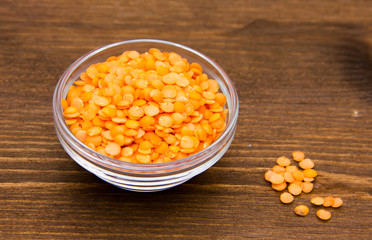 Red lentils on bowl on wooden table