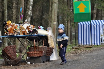 A child watching a toy stall. Wicker baskets, Bialowieza