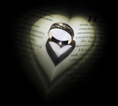 Golden ring in the open book fall some shadow like a hearts