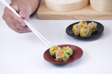 Chef using chopsticks hold Chinese dumpling