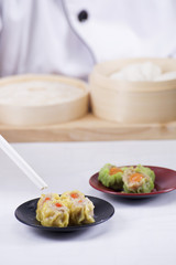 Chef using chopsticks hold Chinese dumpling